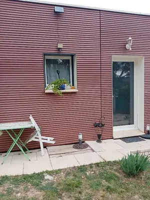 a red building with a window and a bench at studio Erilys in Apt