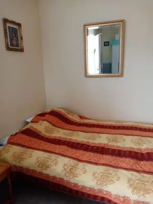 a bed in a room with a mirror at studio Erilys in Apt