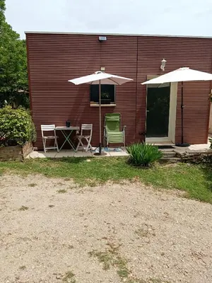 a patio with a table and two chairs and an umbrella at studio Erilys in Apt