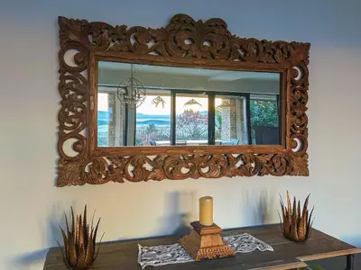 a mirror on a wall above a table with a candle at Mas La Rose Sauvage - magnificent Luberon views in Murs