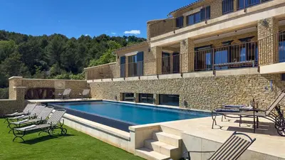 a swimming pool in front of a building at Mas La Rose Sauvage - magnificent Luberon views in Murs