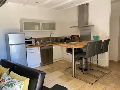 a kitchen with a wooden table and a refrigerator at Mas du Soleil in Caumont-sur-Durance