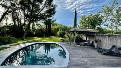 a swimming pool with chairs and a wooden deck at B&B 2 Chambres d'hôtes Gai Félibre avec Piscine et Jacuzzi in Le Thor