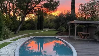 a reflection of two people in a swimming pool at B&B 2 Chambres d'hôtes Gai Félibre avec Piscine et Jacuzzi in Le Thor