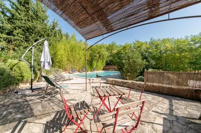 a patio with a table and chairs and a pool at Mas Titourin - Moulin du 18ème entièrement rénové in Ansouis