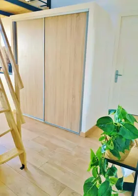 a room with a wooden door and a plant at Grand studio lumineux au calme, centre historique in Pertuis