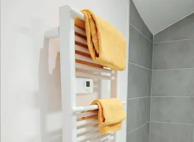 a bathroom with a white towel rack with towels at Grand studio lumineux au calme, centre historique in Pertuis