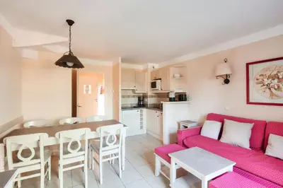 a living room with a red couch and a table at Les Coteaux de Pont Royal en Provence - maeva Home - Maison climatisée 3 pièces 6 personnes - Sélection MAE-5714 in Mallemort