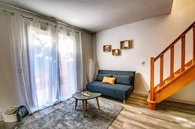 a living room with a blue couch and a staircase at Les quatre loges n°1 in Aix-en-Provence
