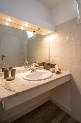 a bathroom with a sink and a large mirror at Les quatre loges n°1 in Aix-en-Provence