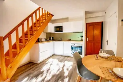 a kitchen with a wooden table and a wooden staircase at Les quatre loges n°1 in Aix-en-Provence