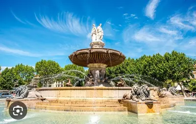 a fountain in a park under a blue sky at Les quatre loges n°2 in Aix-en-Provence