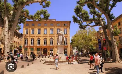 a group of people walking around a building with a statue at Les quatre loges n°2 in Aix-en-Provence
