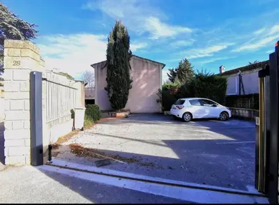 a white car parked in a driveway next to a fence at Les quatre loges n°2 in Aix-en-Provence