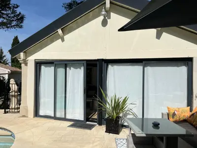 a house with sliding glass doors and a table at Maison cottage en Provence, Spa & piscine, pour 4 personnes- Gîtes Les Estelles in Cavaillon