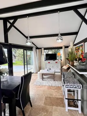 a living room with black and white furniture and a table at Maison cottage en Provence, Spa & piscine, pour 4 personnes- Gîtes Les Estelles in Cavaillon