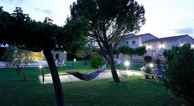 a hammock in a yard with a house at Chambres d'hôtes Le Saint Victor - Provence, Vaucluse in Pernes-les-Fontaines