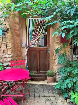 a red table and chairs in front of a door at Maisonnette au pied du Mont Ventoux ste colombe in Bédoin