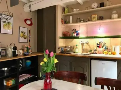 a kitchen with a table with a vase of flowers at Maisonnette au pied du Mont Ventoux ste colombe in Bédoin