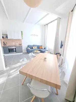 a living room with a wooden table and a couch at Appartement lumineux , Carpentras centre in Carpentras