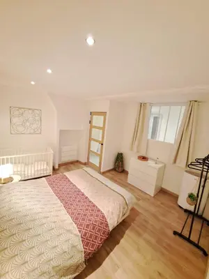 a bedroom with a large bed and wooden floors at Appartement lumineux , Carpentras centre in Carpentras