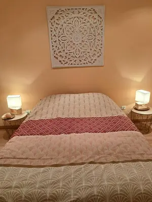 a bedroom with a bed with two lamps on two tables at Appartement lumineux , Carpentras centre in Carpentras