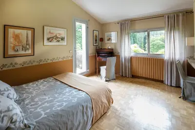 a bedroom with a bed and a desk and window at VillaOustal. Parc Arboré 4500 m2. Piscine chauffée. in Carpentras