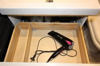 a black remote control in a wooden box under a sink at Studio centre historique derrière rue d'Italie - Climatisé in Aix-en-Provence
