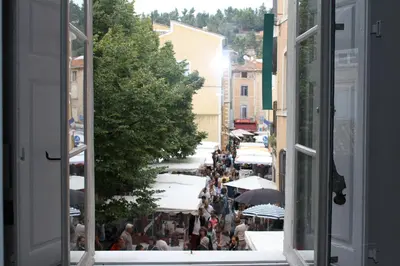 a crowd of people walking down a street with umbrellas at Luxury two bedroom apartment in Apt, the heart of the Luberon in Apt