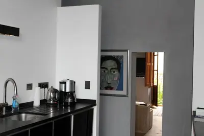 a kitchen with a painting of a face on the wall at Luxury two bedroom apartment in Apt, the heart of the Luberon in Apt