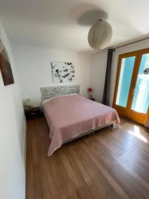 a bedroom with a bed with a pink blanket at Villa La Ressourcerie a Saignon in Saignon