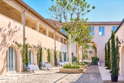 a courtyard of a building with tables and chairs at Auberge La Coste in Le Puy-Sainte-Réparade