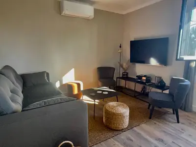 a living room with a couch and chairs and a tv at LA VILLA 81 in Mormoiron