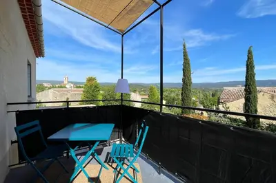 a table and chairs on a balcony with a view at LA VILLA 81 in Mormoiron