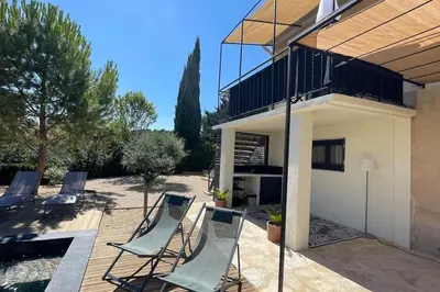 a group of chairs on a patio next to a house at LA VILLA 81 in Mormoiron