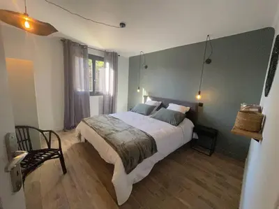 a bedroom with a large bed and a chair at LA VILLA 81 in Mormoiron