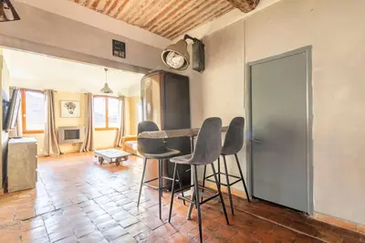 a living room with a table and chairs in it at Authentique Appartement Aixois in Aix-en-Provence