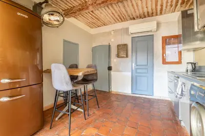 a kitchen with a table and some stools in it at Authentique Appartement Aixois in Aix-en-Provence