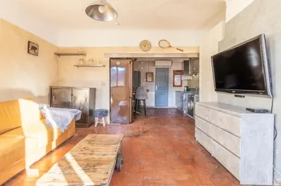 a living room with a couch and a flat screen tv at Authentique Appartement Aixois in Aix-en-Provence
