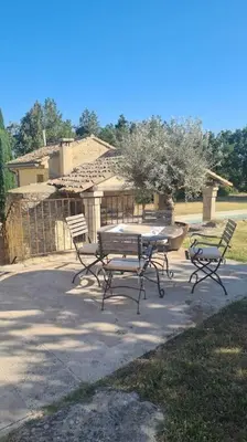 a picnic table and chairs in front of a house at Authentique propriété in Bonnieux