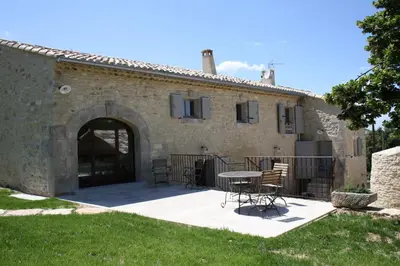 a patio outside of a stone building with a table and chairs at Authentique propriété in Bonnieux
