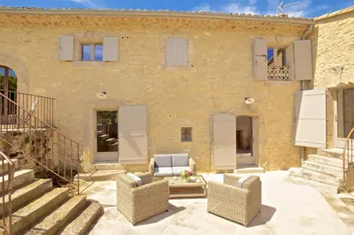 a brick house with two chairs and a patio at Authentique propriété in Bonnieux