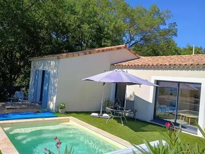 a pool with an umbrella next to a house at Villa Abelha en Provence in Apt