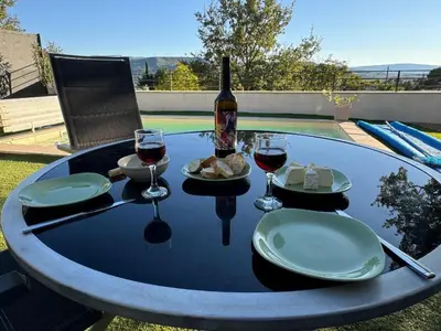 a table with a bottle of wine and plates of food at Villa Abelha en Provence in Apt