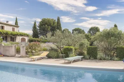 a swimming pool with two benches next to a house at Mas de Lavande in Saint-Rémy-de-Provence