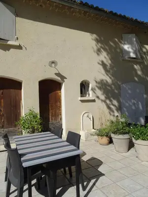 a table and chairs in front of a building at Logement charme provençal in Cabannes