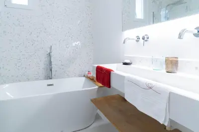 a white bathroom with a tub and a sink at Alma Viva - Piscine Privée - Climatisée - Parking in Velaux