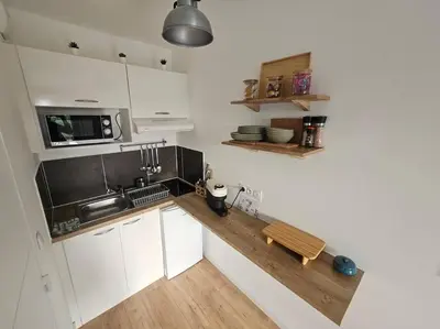a kitchen with white cabinets and a wooden counter top at 104 Douce Provence au calme face à la piscine in Éguilles