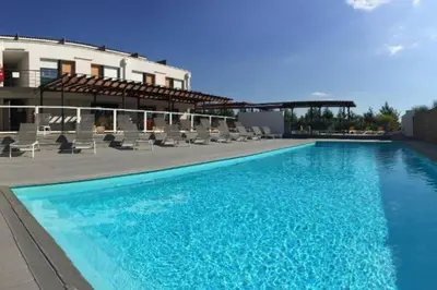 a large blue swimming pool next to a building at 104 Douce Provence au calme face à la piscine in Éguilles