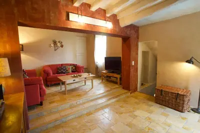 a living room with a red couch and a table at La Paradisse – exceptional Provençal farmhouse (18th century) in Blauvac